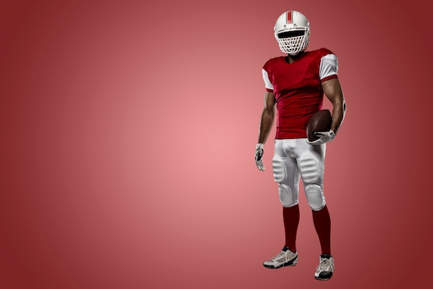 Football Player with a red uniform on a Red wall