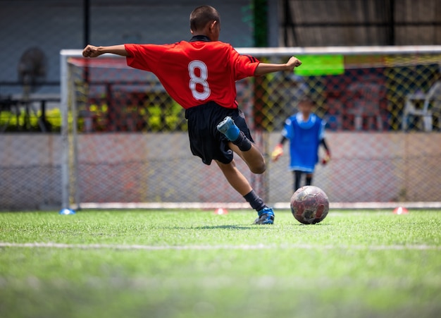 Football soccer training for kids. Coach explaining the game plan. Young boys improving soccer skills local Thailand