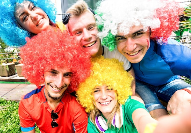 Football supporter fans friends taking selfie after soccer cup match hanging around together