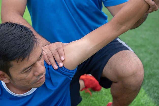 Photo footballer wearing a blue shirt, black pants injured in the lawn during the race.