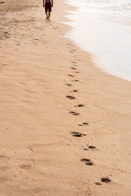 Photo footprints of a man walking on the beach travel concept