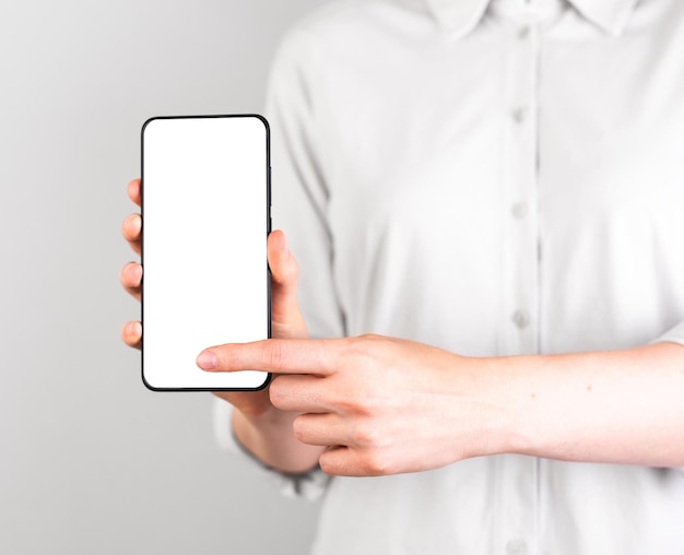 Forefinger pressing ok button at phone mockup Woman holding Android template with blank display in vertical position Digital technologies in modern life