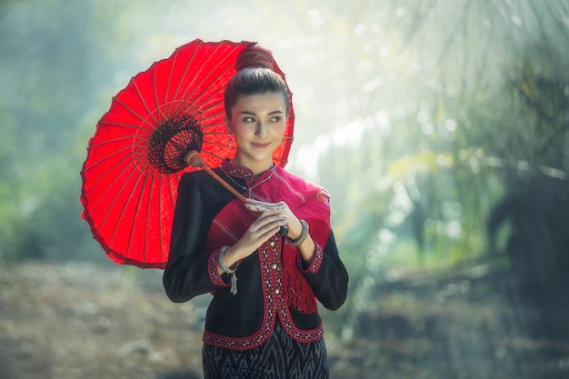 Foreign women wearing typical (traditional) with red umbrella and red breast cloth