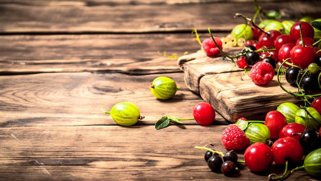 Forest berries on the Board. On a wooden table.