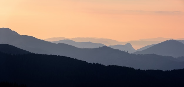 Forest mountain range scene at sunrise. Sunrise in the mountains. Mountain panoramic landscape.