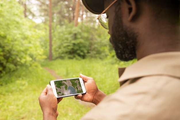 Forest warden holding smartphone side view