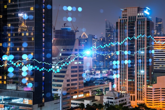 FOREX graph hologram aerial night panoramic cityscape of Bangkok the developed location for stock market researchers in Asia The concept of fundamental analysis Double exposure