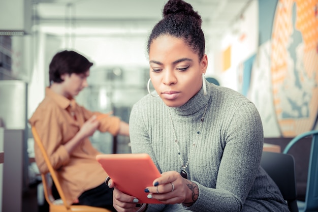 Forgetting about everyone. The young woman gripped with texting online and not noticing her friend