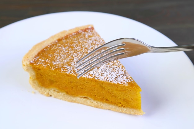 Fork Cutting a Slice of Delectable Freshly Baked Pumpkin Pie