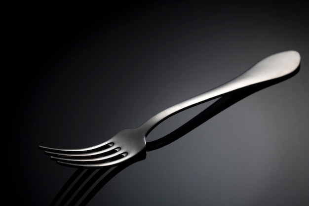 Fork with spot light on black table.