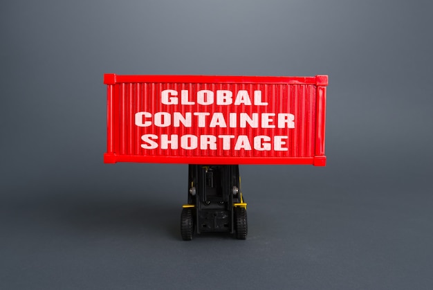 Forklift lifts the container with the inscription Global container shortage Logistics problems