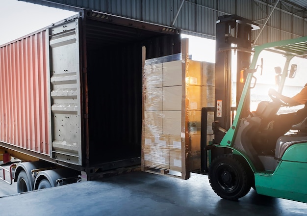 Forklift Tractor Loading Package Boxes into Shipping Cargo Container Warehouse Logistics Transport