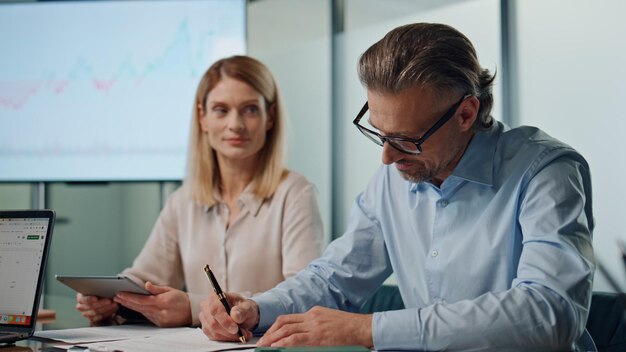 Formal businessman signing contract indoors closeup partners shaking hands deal