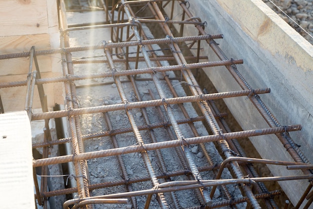 Foundation site of new building details and reinforcements with steel bars and wire rod in wooden decking preparing for cement pouring