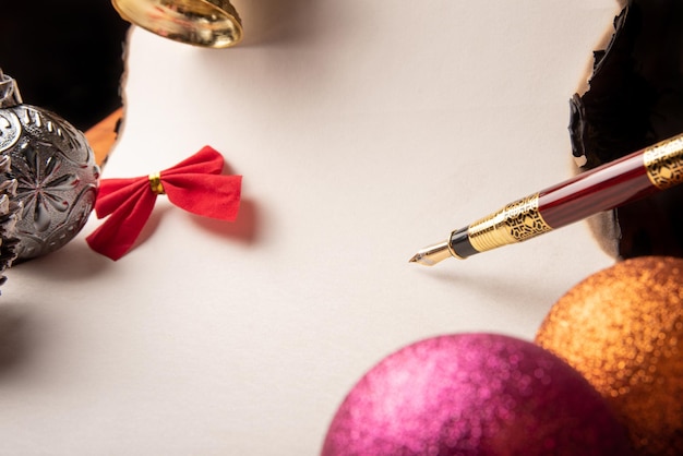 Fountain pen a beautiful fountain pen a blank sheet with burnt edges and Christmas ornaments Selective focus