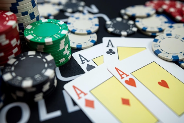 Four Ace playing cards with chips on casino table