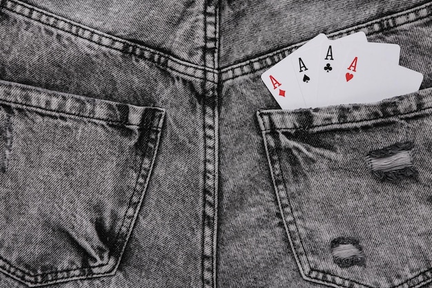 Four aces in the back pocket of gray jeans