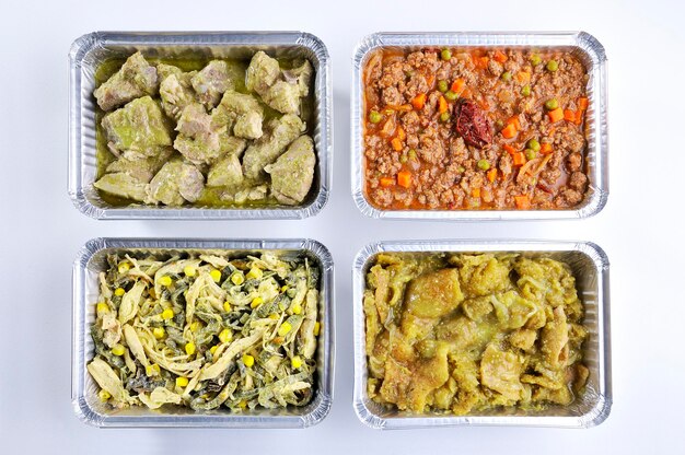 Four aluminum containers with takeaway meals