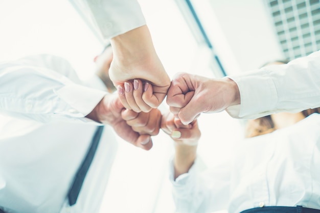 Photo the four business people greeting with a fist