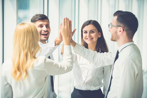 The four business people greeting with a high five