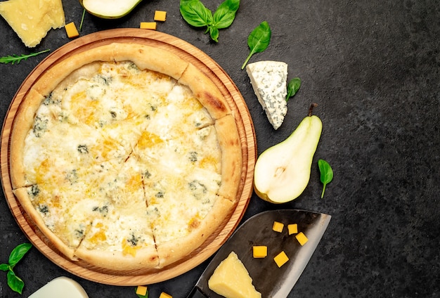 four cheese pizza with ingredients on stone background with copy space for your text