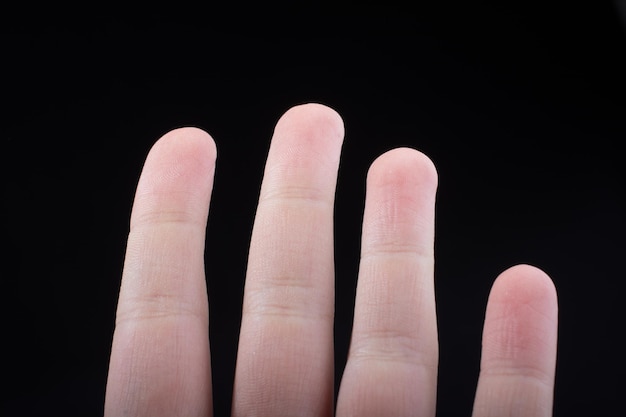 Four fingers of a human hand partly seen in view