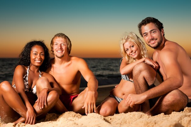 Four friends at sunset beach