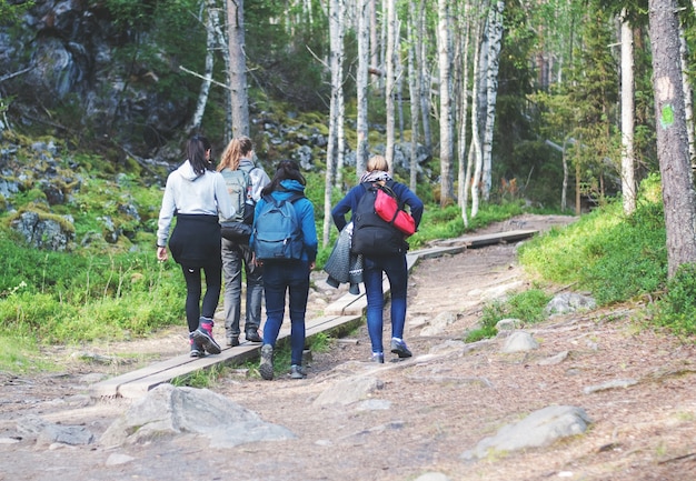 Four girls walking on a hiking trail in forest