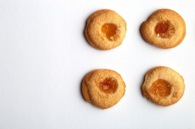 Four handmade cookies with apricot jam arranged in even rows with free space