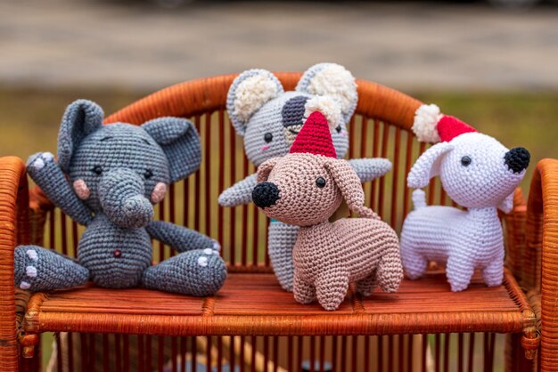 Four handmade knitted toys on wicker shelf