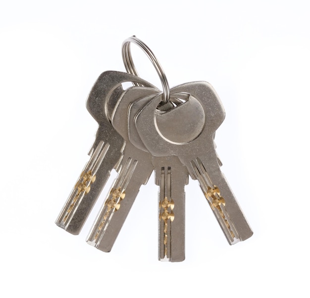 Four house keys on a key ring isolated on a white background.