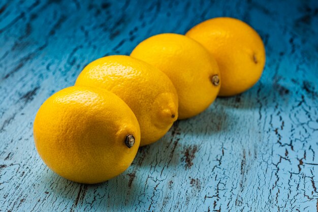 Four lemons on blue table