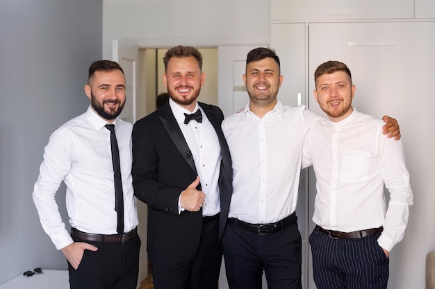 Four men in suits and ties stand together, one of them has a thumbs up.