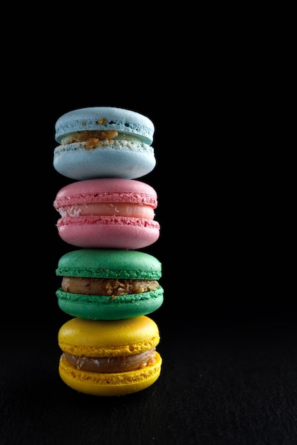 Four multi-colored homemade natural products macaroon on a black background