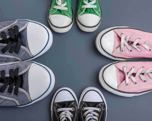 Four pairs of old textile sneakers on black