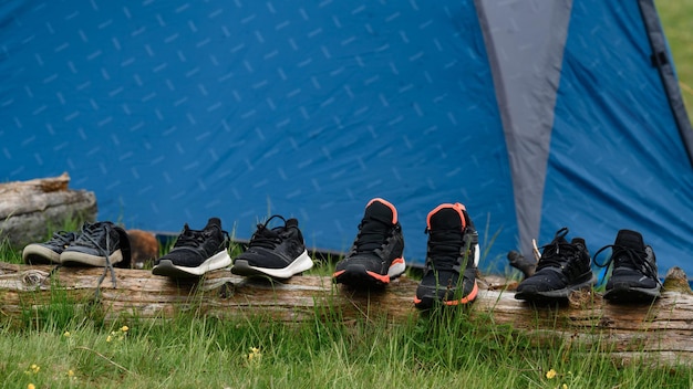 Four pairs of trekking shoes are drying near the tent