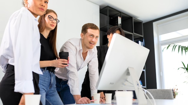 Four people of different nationalities are working on a project in the office