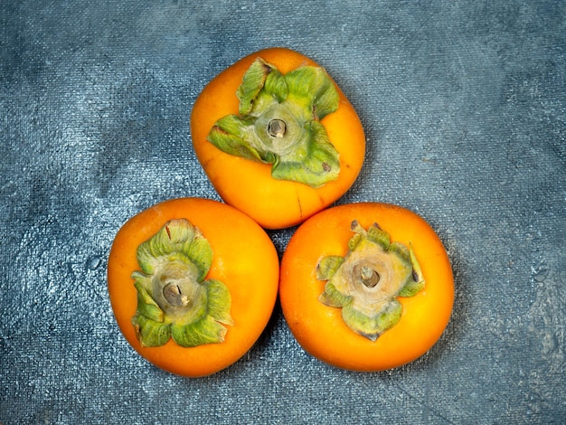 Four persimmons on a black background Persimmon varieties Chamomile