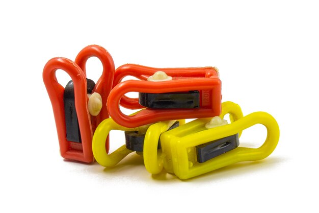 Photo four plastic clothespins red and yellow steel springs are visible isolated background