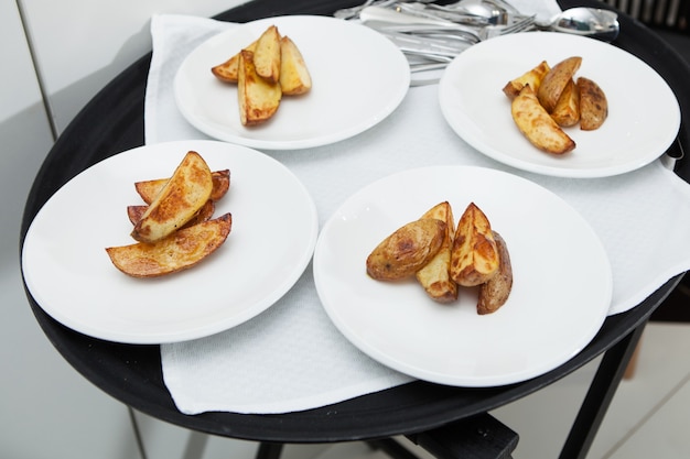 Four plates with slices of delicious fried potatoes.