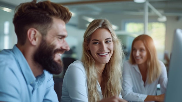 Four professionals are sitting in a row at a desk smiling as they look towards a computer screen engaged in a collaborative work environment