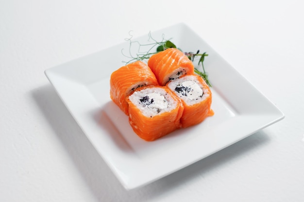 Four red sushi maki rolls decorated with greenery