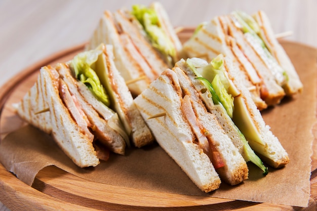 Four sandwiches on wooden table in a restaurant. Fast food