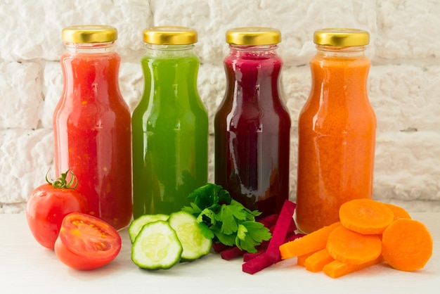 Four vegetable juices in glass bottles A large plan The concept of healthy eating