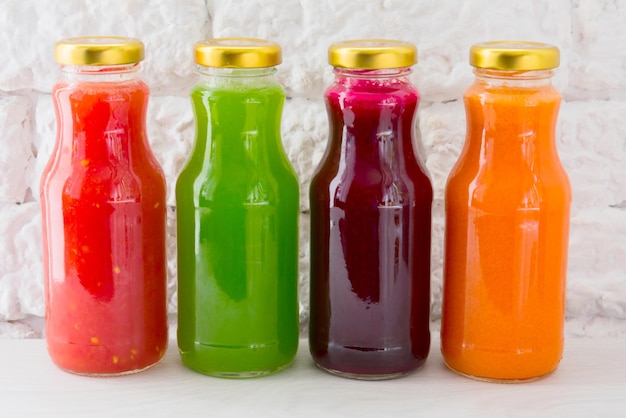 Four vegetable juices in glass bottles A large plan The concept of healthy eating