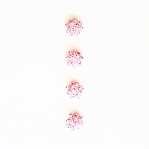 Four white-red bows for decorating Christmas gifts on a white background