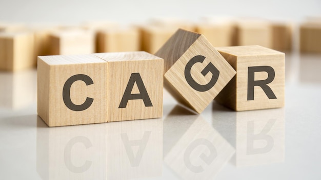 Four wooden blocks with the letters CAGR on the bright surface of a gray table business conceptual word collected of of wooden elements with the letters