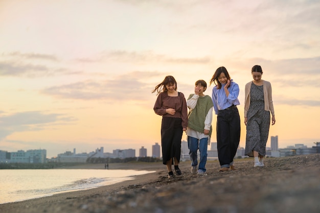 Four young women walking along the sea in the dusk