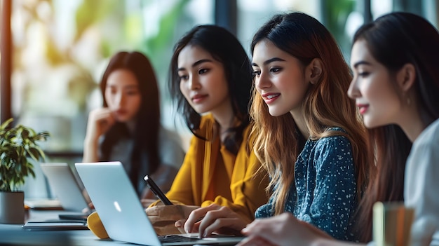 Four Young Women Working on Laptops and Taking Notes in a Modern Office Setting