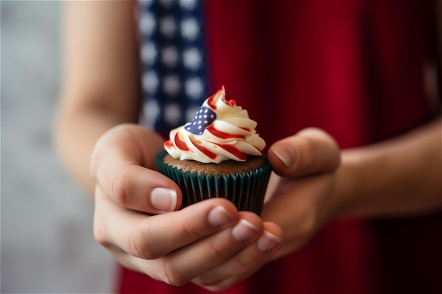 Fourth of july celebration hand holding sweet cupcake with cream flag background